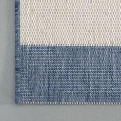 a blue and white rug hanging on the wall