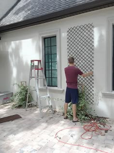 a man is painting the outside of a house