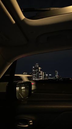 the view from inside a car at night with city lights in the background