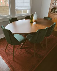 a wooden table with green chairs around it