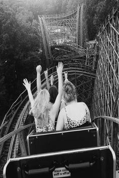 two women riding on a roller coaster with their arms in the air and text that reads,