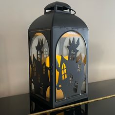 a black lantern with halloween decorations on it