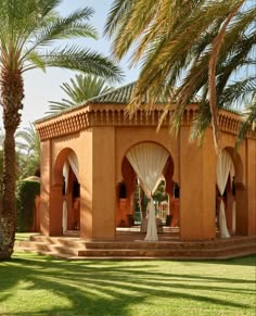 an orange building with white drapes and palm trees