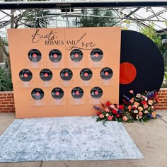 a record display in the middle of a garden with lots of flowers and plants around it