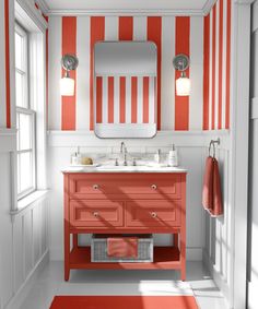 a bathroom with orange and white stripes on the walls, red rugs and sink