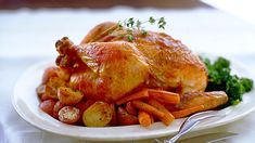 a white plate topped with chicken, potatoes and broccoli next to a fork