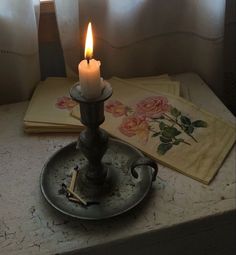 a lit candle sitting on top of a metal tray