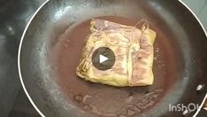 a piece of food sitting in a frying pan on top of a stovetop