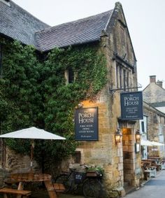 an old stone building with tables and umbrellas outside