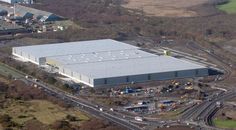 an aerial view of a large industrial building in the middle of a country side town