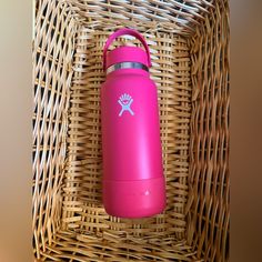 a pink water bottle sitting on top of a wicker basket