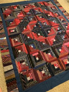 a quilt is laying on the floor with red and black squares in it's center