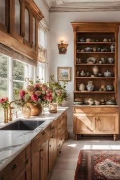 a kitchen filled with lots of wooden cabinets and counter top space next to a window