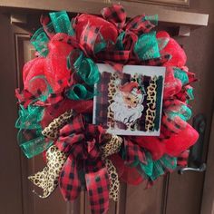 a red and green christmas wreath on the front door