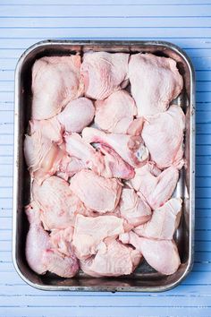 raw chicken in a pan on a blue background