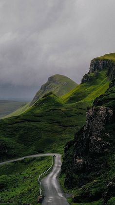 a winding road in the middle of green hills