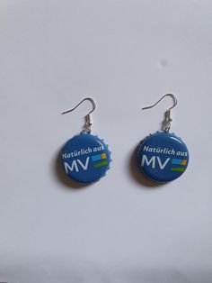 two blue bottle caps with the words nattilitich au and m v on them