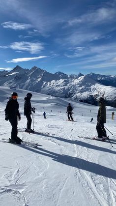 several people on skis in the snow with mountains in the backgroung