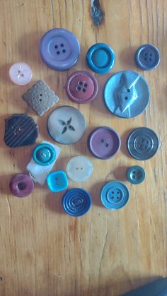 many different colored buttons on a wooden table