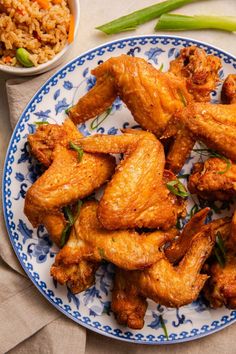 chicken wings on a blue and white plate next to rice