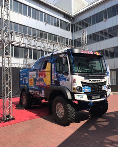 a truck parked in front of a tall building