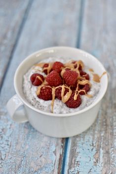 a white bowl filled with oatmeal and raspberries