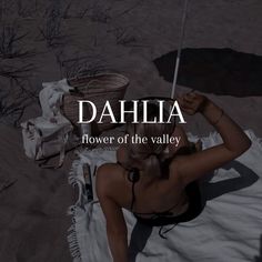 a woman laying on top of a towel under an umbrella in the sand with words above her reading dahla flower of the valley