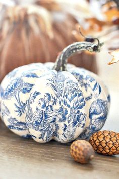 two blue and white pumpkins sitting on top of a table