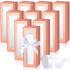 six pink boxes with white ribbons and bows on them, all lined up against one another