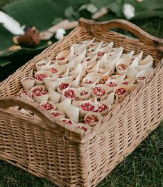 a wicker basket filled with food on top of grass