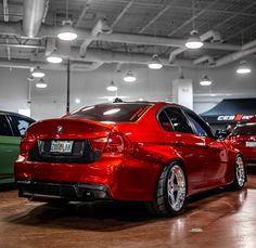 a red car parked in a garage next to other cars