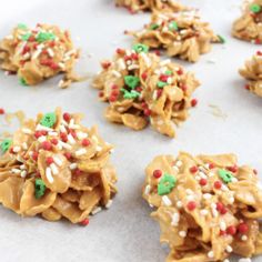 cookies with sprinkles and colored candies are on a baking sheet, ready to be eaten