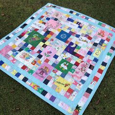 a patchwork quilt is laying on the grass