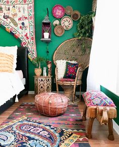 a bedroom with green walls and colorful rugs on the floor next to a bed