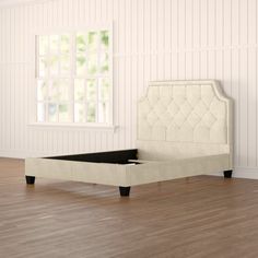 a white bed sitting on top of a hard wood floor