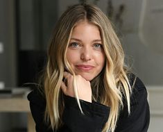 a woman with long blonde hair sitting down