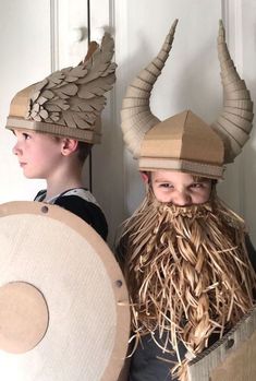 two young boys dressed in costumes made out of cardboard and fake hair, with horns on their heads