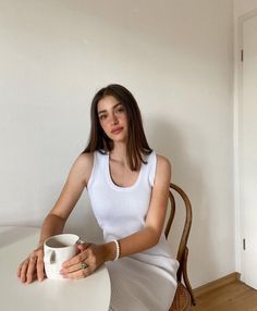 a woman sitting at a table with a coffee cup