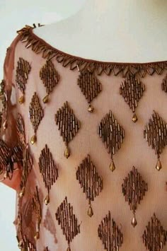 the back of a woman's dress with beading on it