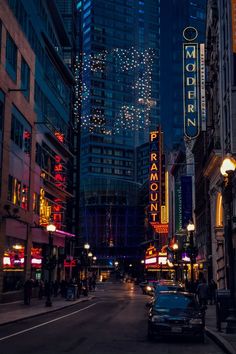 a city street filled with tall buildings at night