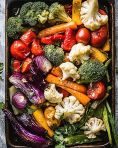 a tray full of vegetables including broccoli, cauliflower and tomatoes