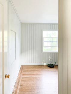 an empty room with wood floors and white walls