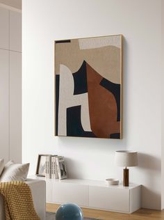 an abstract painting hangs on the wall next to a white couch and coffee table in a living room