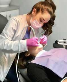 a woman getting her teeth checked by a dentist