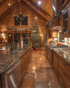 a christmas tree is in the middle of a kitchen with granite counter tops and wooden cabinets