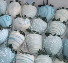 blue and white chocolate covered strawberries with sprinkles on the top are arranged in rows