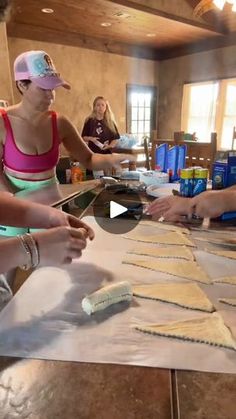 two women are making pizza dough on a table