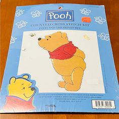 the winnie the pooh cross stitch kit is laying on top of a wooden table