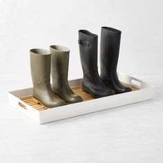 three pairs of rain boots are sitting on a tray