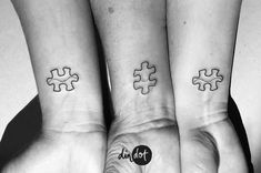 three people with matching tattoos on their wrists are holding hands in the shape of puzzle pieces